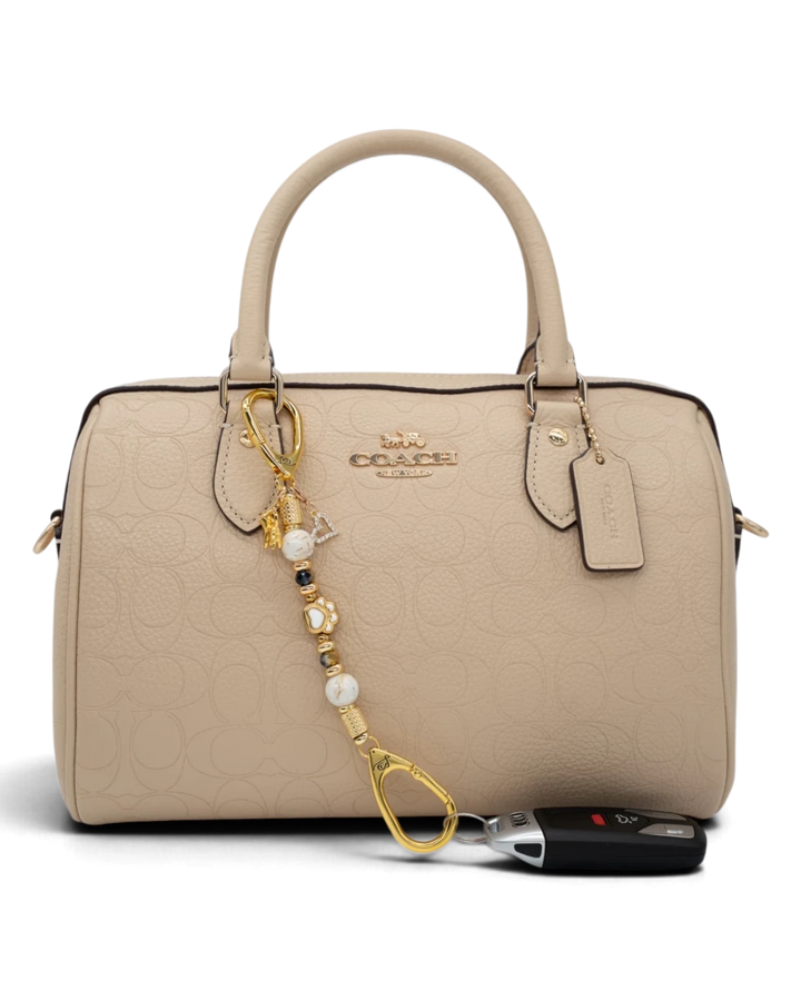 LD Keyfinder Furever Love-Mini charm with white seashell and gold beads, dog paw, heart, and dog charms on a handbag