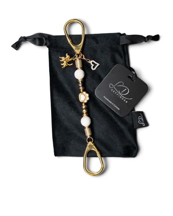 LD Keyfinder Furever Love-Mini keychain with white seashell beads, gold paw charm, and heart charm on velvet bag.