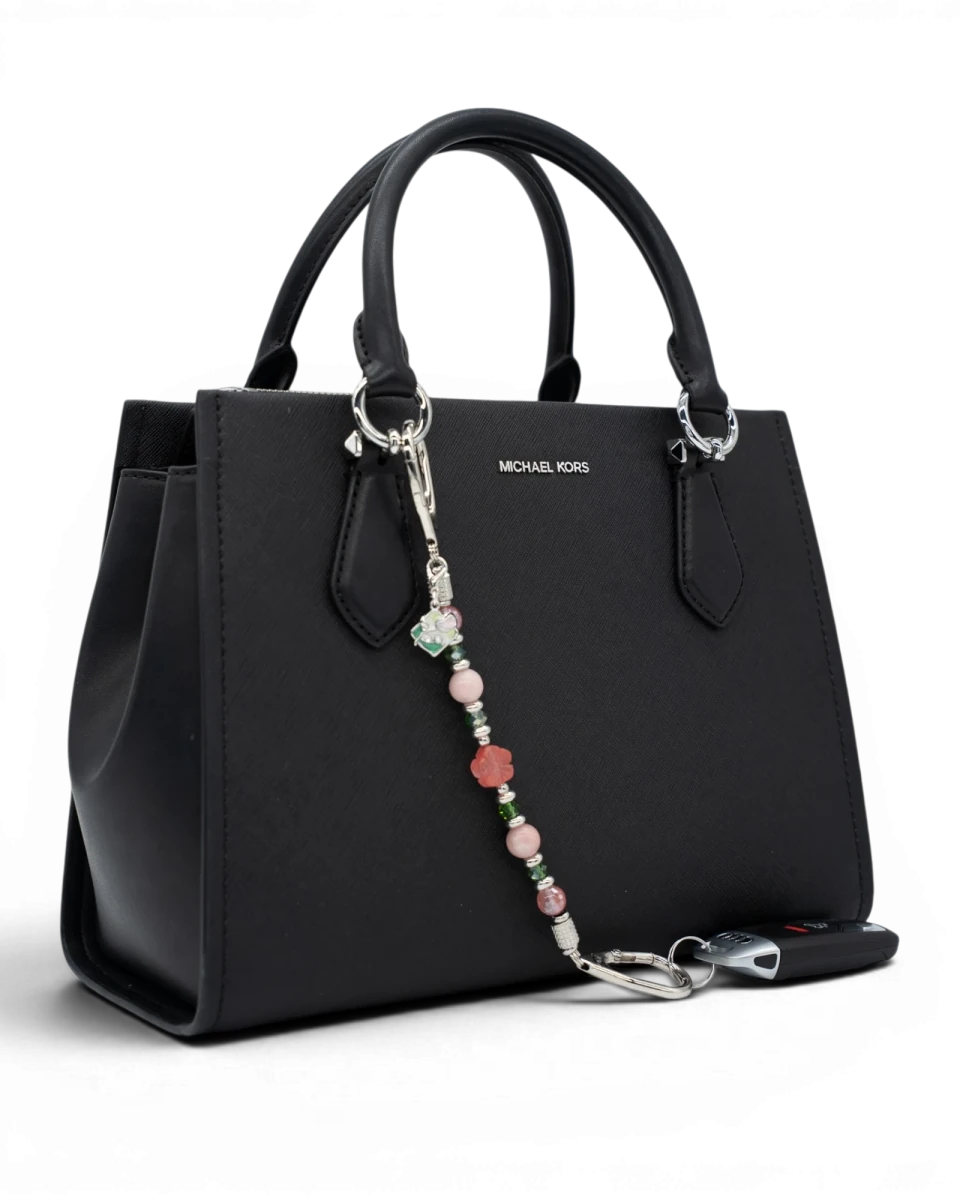 LD Keyfinder Garden Bliss beaded keychain with cherry quartz and pink opal attached to a black Michael Kors handbag.