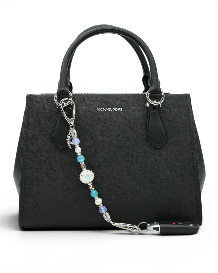 LD Keyfinder Garden Serenade beaded accessory with pearls, opalite, and hummingbird charm attached to a black handbag.
