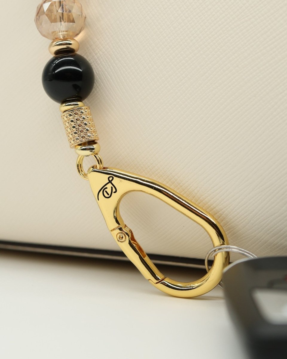 LD Keyfinder Gilded Bee keychain with black obsidian, gold crystal beads, and gold charms. Features a bee and flower charm.