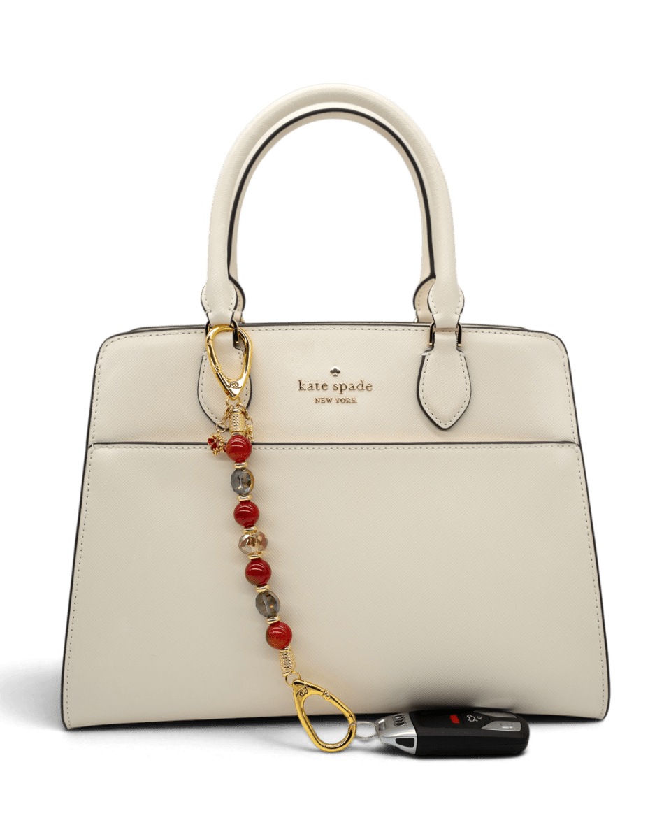 LD Keyfinder Golden Autumn beaded accessory with agate and crystal charms attached to a cream Kate Spade handbag