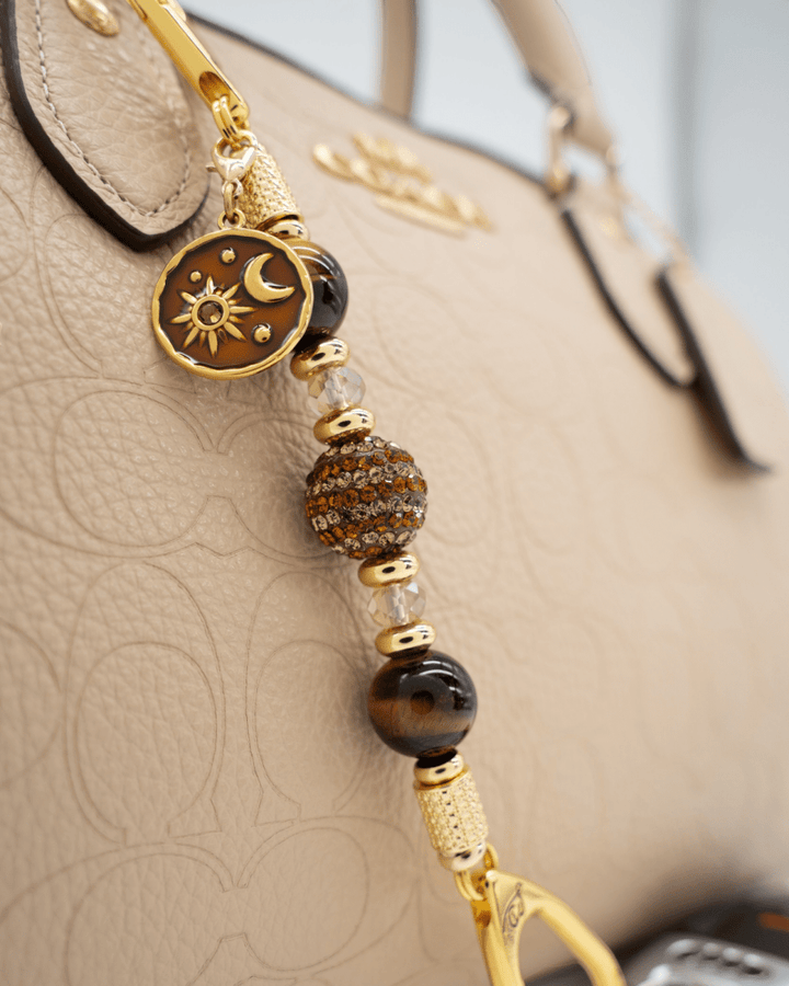 LD Keyfinder Golden Equinox-Mini featuring Tiger Eye beads, gold-plated sun and moon charm, and rhinestone centerpiece.