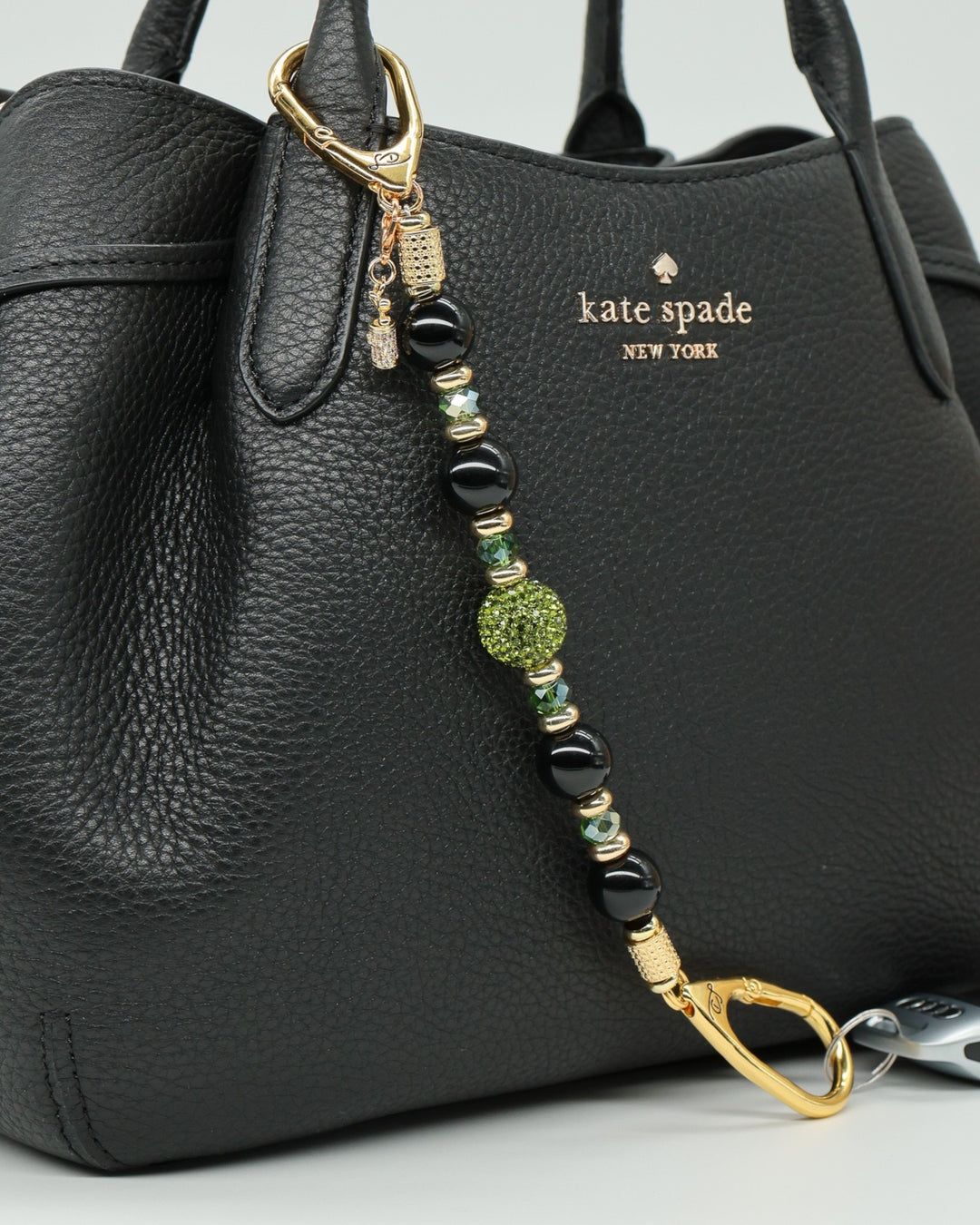 LD Keyfinder Golden Fairway beaded keychain with black obsidian, moss green crystals, and a golf bag charm on a bag.