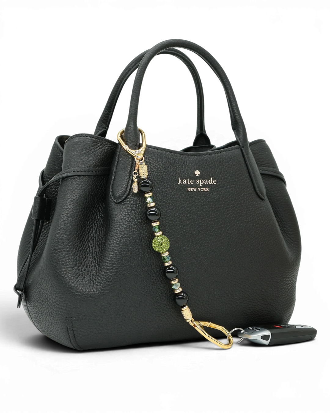 LD Keyfinder Golden Fairway beaded keychain with obsidian, moss green crystals, and a golf bag charm on a black bag.