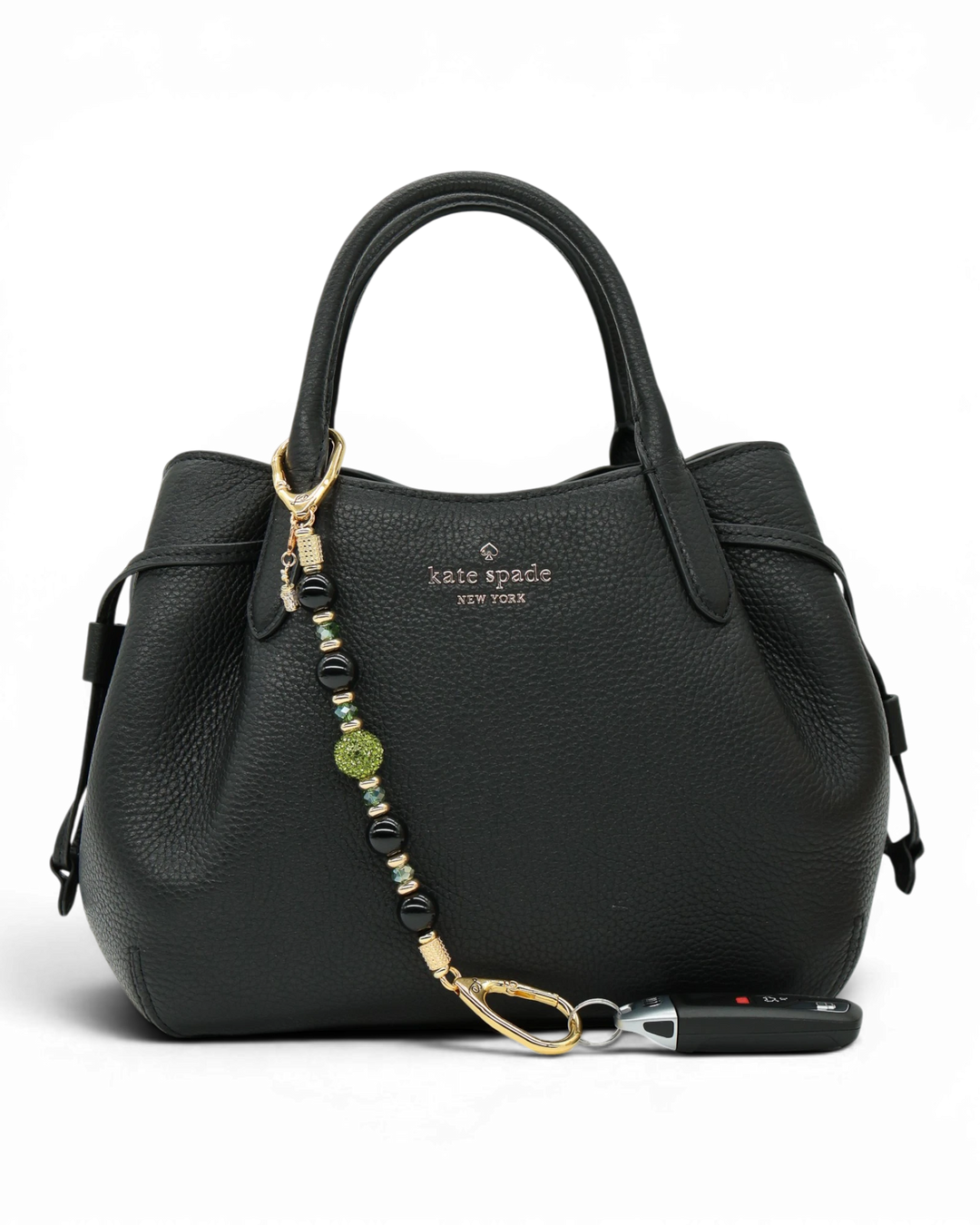 LD Keyfinder Golden Fairway beaded keychain with black obsidian, moss green crystal, and golf bag charm on a handbag.