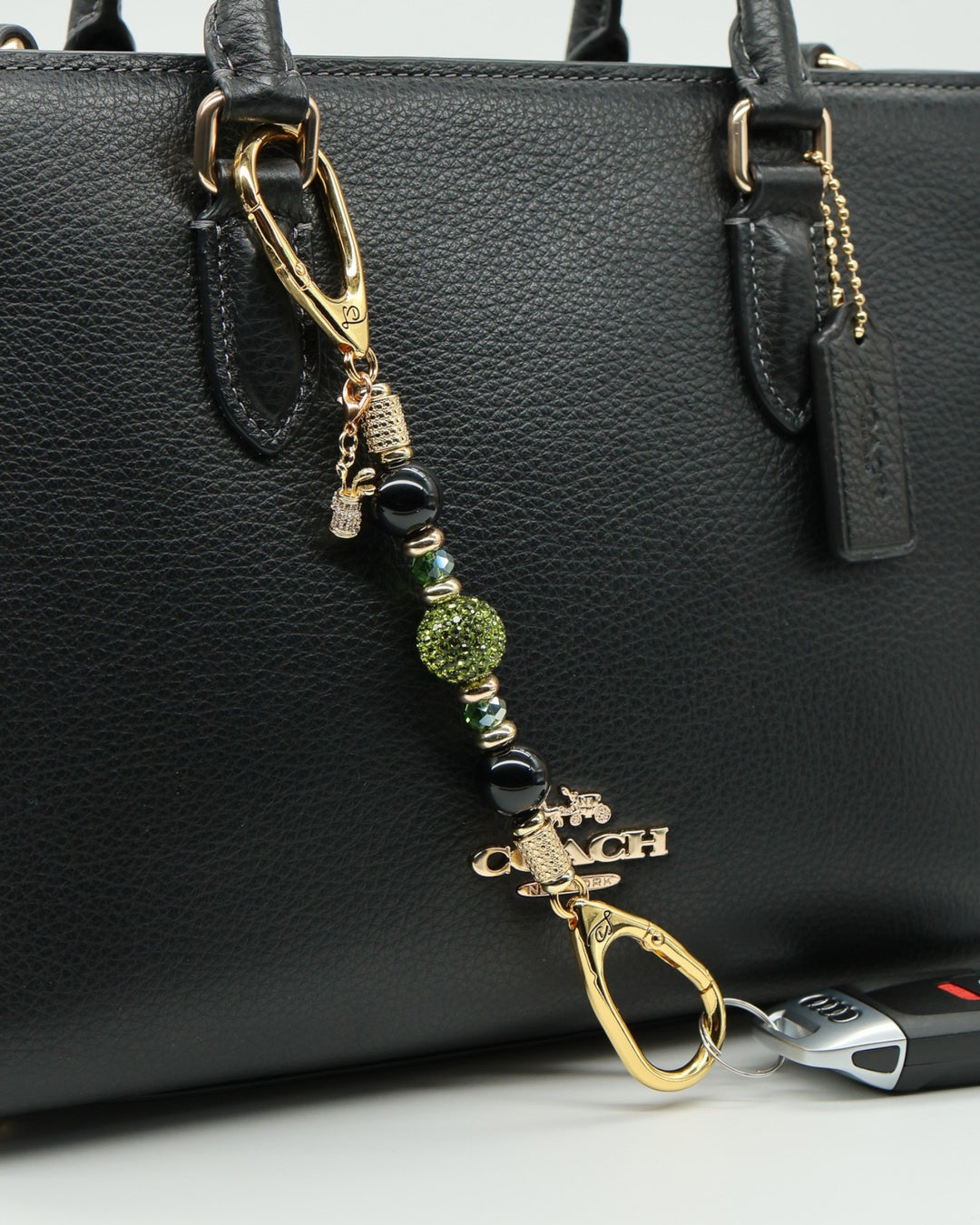 LD Keyfinder Golden Fairway-Mini with black obsidian, moss green crystals, and a rhinestone golf bag charm on a bag.