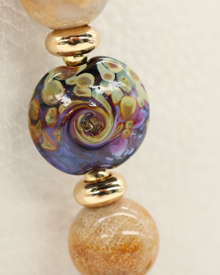 LD Keyfinder Golden Nebula bracelet with artisan glass bead, fossil coral, amethyst, and gold-plated accents.