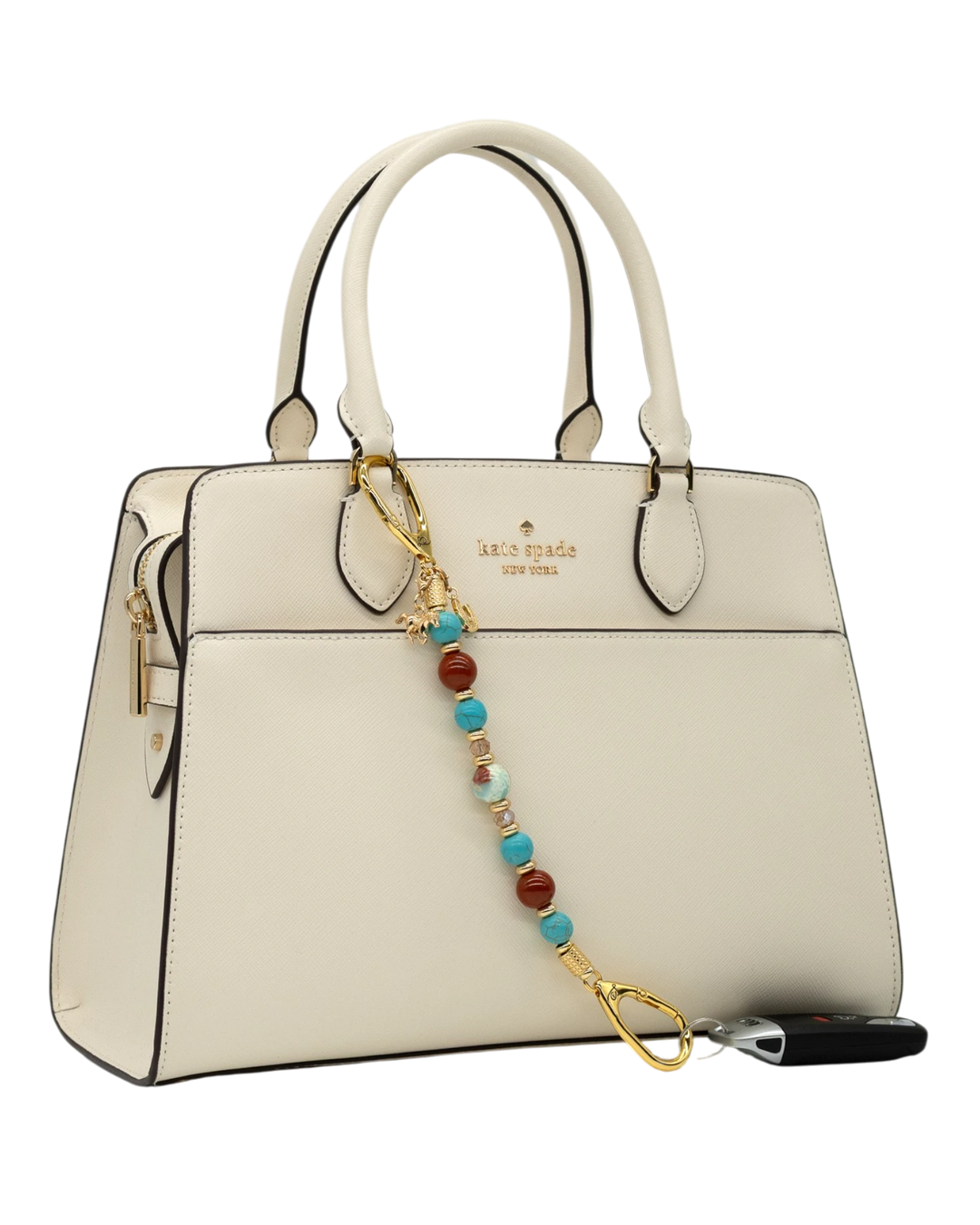LD Keyfinder Golden Prairie beaded accessory with turquoise, red jasper, and gold charms attached to a white handbag.