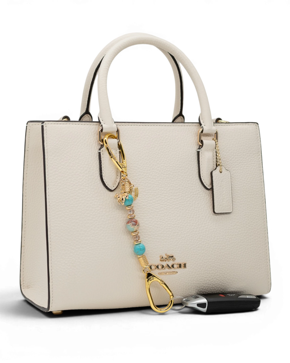 LD Keyfinder Golden Prairie-Mini beaded charm with turquoise and gold accents attached to a white leather handbag.
