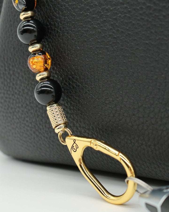 LD Keyfinder Golden Purrs beaded accessory with black obsidian, gold foil lampwork glass, and gold-plated hardware.
