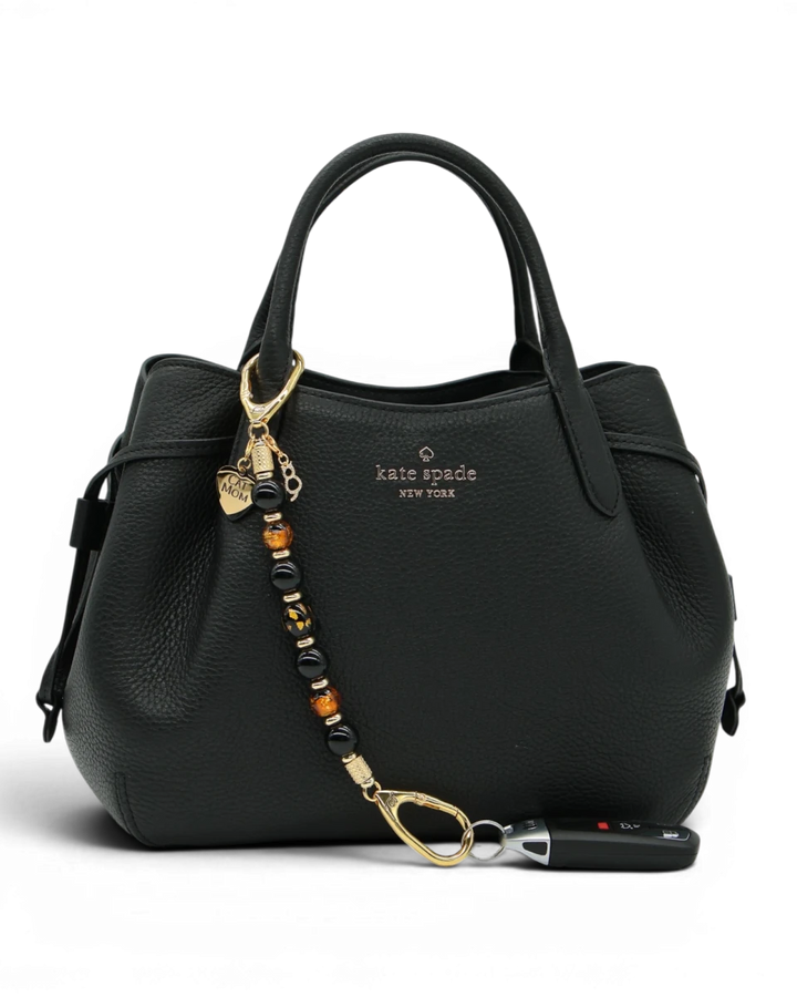 LD Keyfinder Golden Purrs beaded key accessory with black obsidian and gold foil cat charms attached to a black bag.