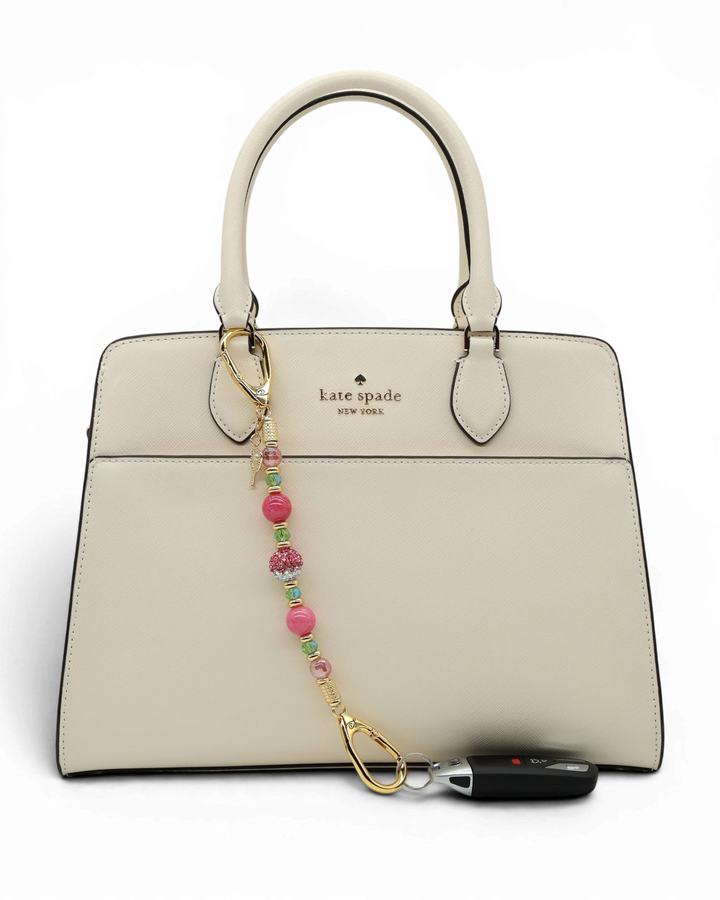 LD Keyfinder Golden Rally beaded keychain with pink quartz, lime green glass, and a pickleball paddle charm on a bag.