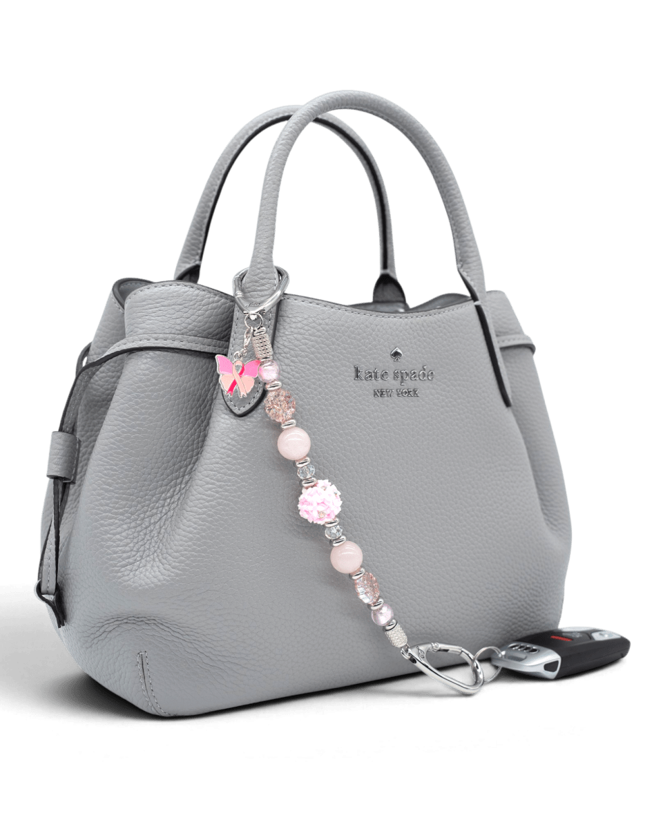 LD Keyfinder Hope Blooms beaded keychain with pink rose quartz, glass flowers, and a pink ribbon butterfly charm on a bag
