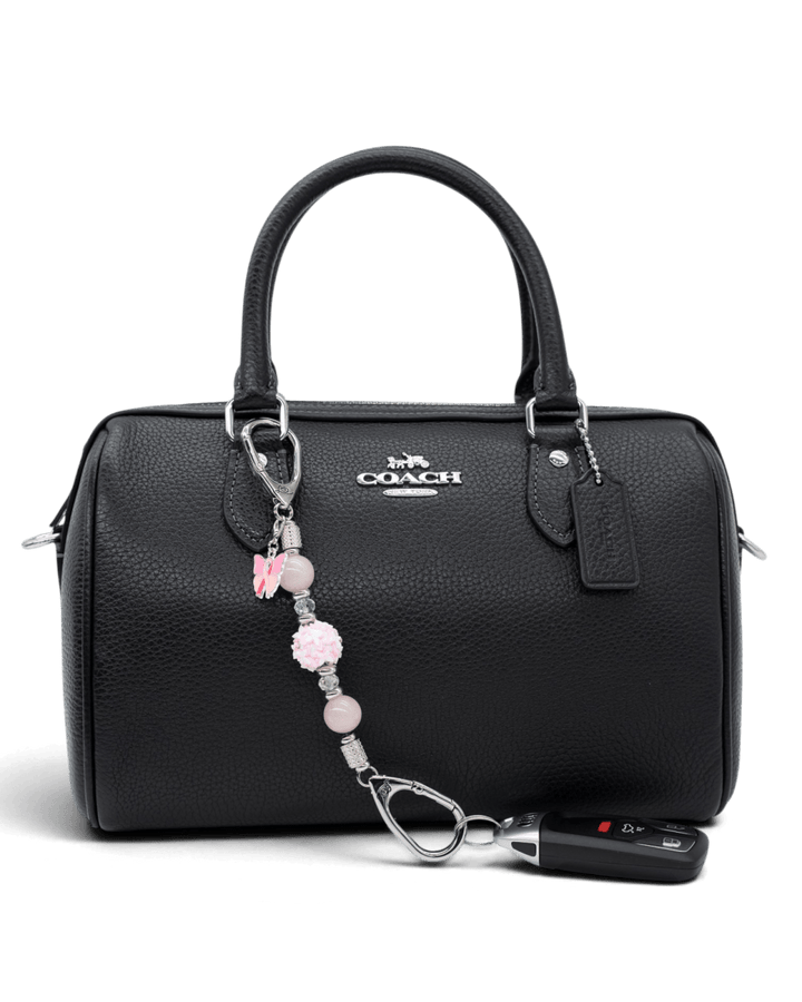 LD Keyfinder Hope Blooms-Mini beaded charm with rose quartz and butterfly attached to a black leather handbag