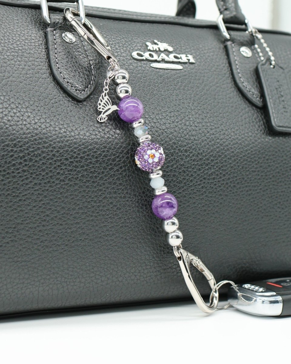 LD Keyfinder Hummingbird Dream Mini keychain with amethyst, crystal daisy bead, and hummingbird charm on black bag.