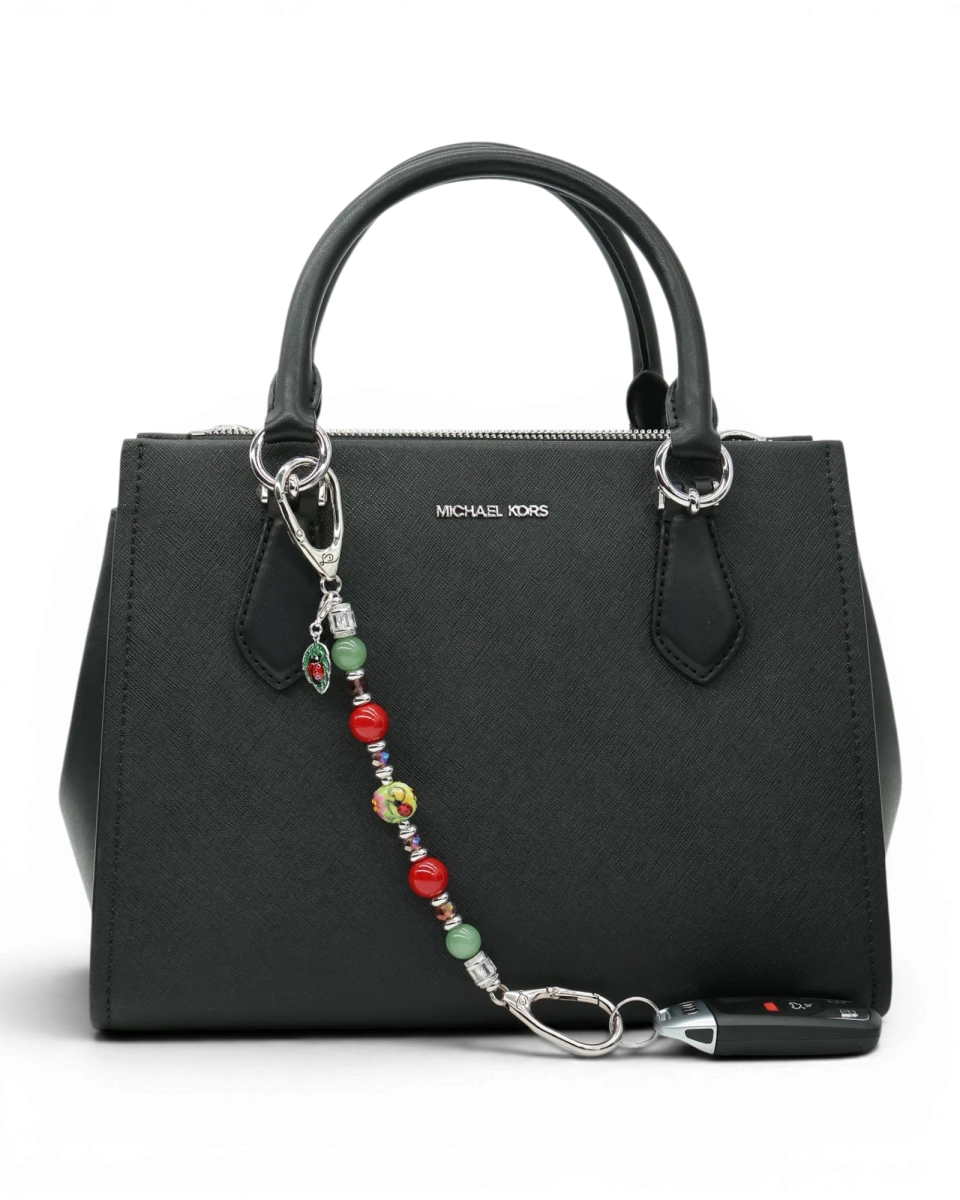 LD Keyfinder Ladybug Love accessory with artisan glass, aventurine, and shell pearl beads attached to a black handbag.