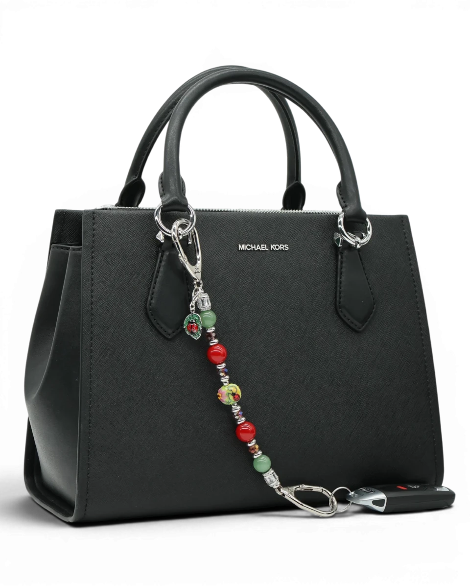 LD Keyfinder Ladybug Love beaded keychain with artisan glass, aventurine, and red shell pearls on a black handbag.