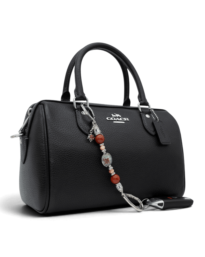 LD Keyfinder Petite Maple Majesty accessory with red jasper and artisan glass beads attached to a black leather handbag
