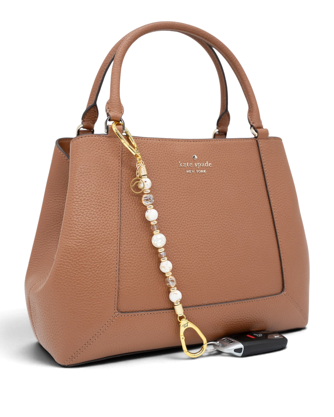 LD Keyfinder Mediterranean Glow beaded accessory with Mother of Pearl, ivory shells, and gold charms on a brown bag