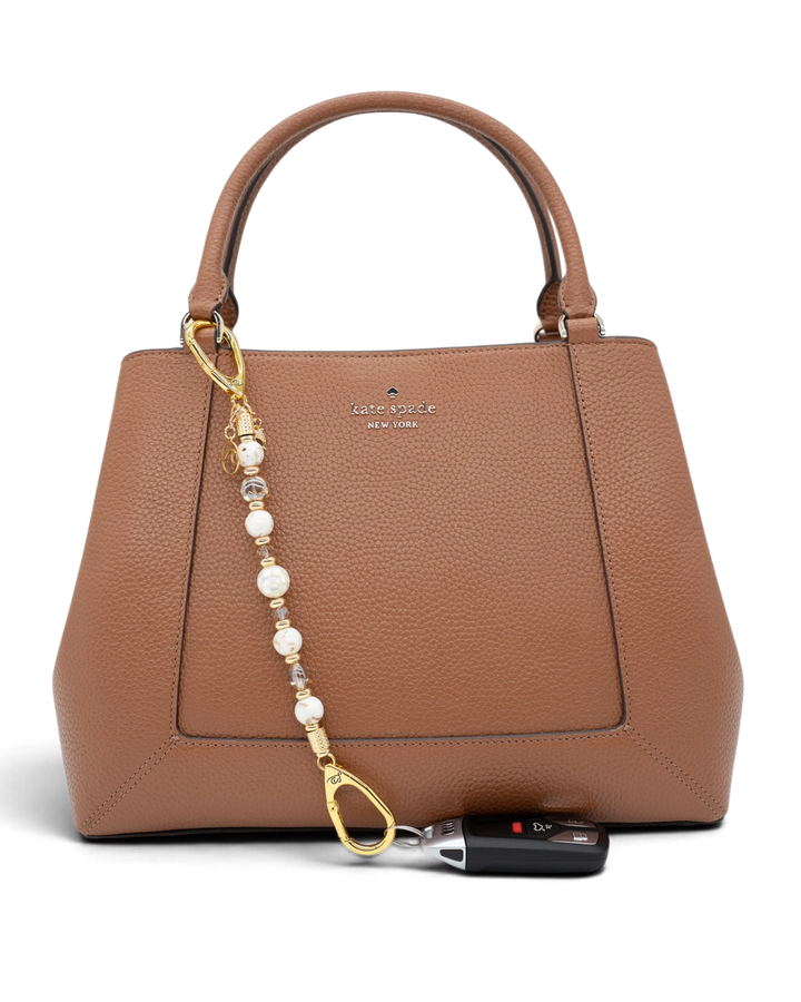LD Keyfinder Mediterranean Glow beaded accessory with Mother of Pearl and gold charms attached to a brown leather bag
