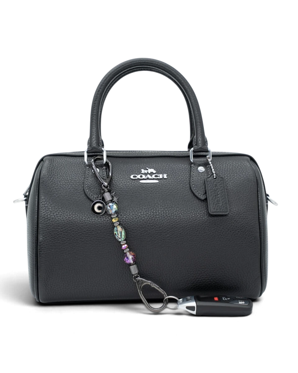 LD Keyfinder Midnight Aurora-Mini beaded keychain with abalone shell and rainbow crystals attached to a black handbag.