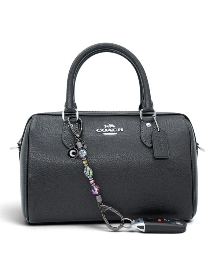 LD Keyfinder Midnight Aurora-Mini beaded keychain with abalone shell and rainbow crystals attached to a black handbag.
