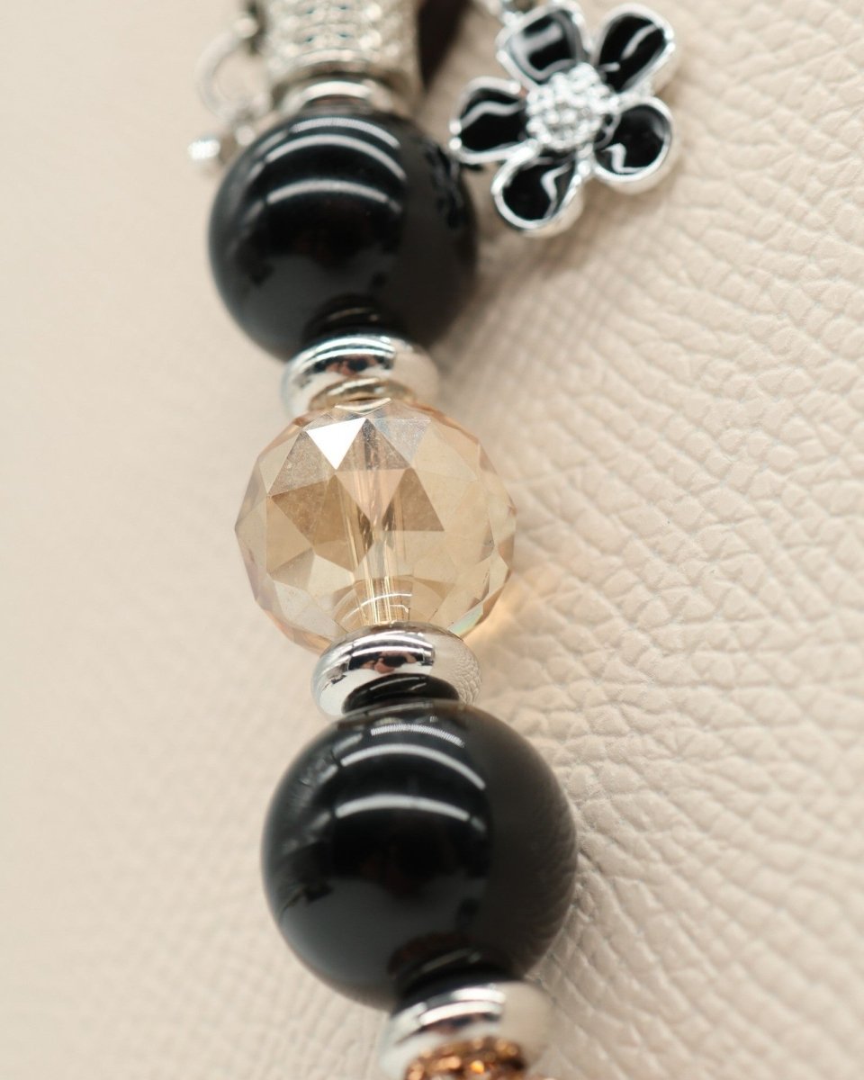 LD Keyfinder Midnight Hive bracelet with black obsidian, crystal, and charms. Features a bumblebee and flower.