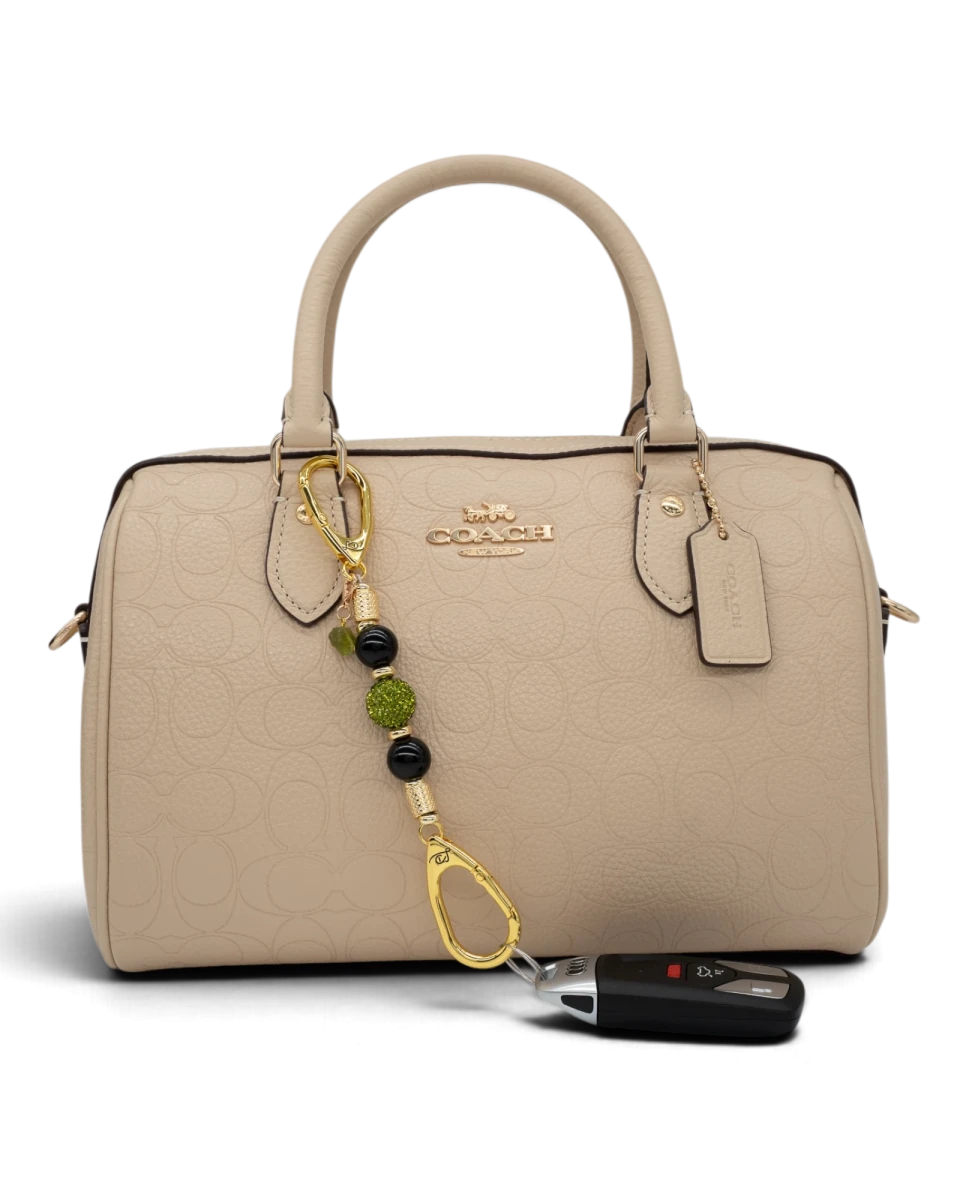 LD Keyfinder Midnight Peridot-Mini beaded charm with black obsidian and green crystals attached to a beige handbag