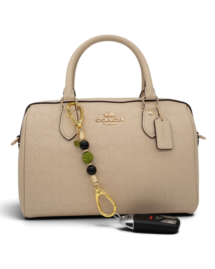 LD Keyfinder Midnight Peridot-Mini beaded charm with black obsidian and green crystals attached to a beige handbag
