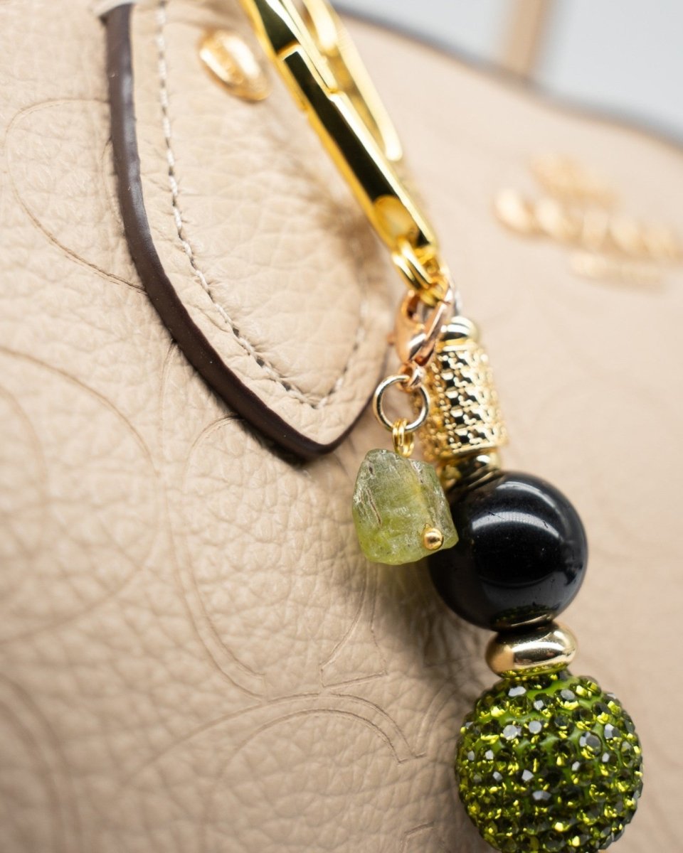 LD Keyfinder Midnight Peridot-Mini charm featuring black obsidian, green crystal beads, and raw peridot on a handbag.
