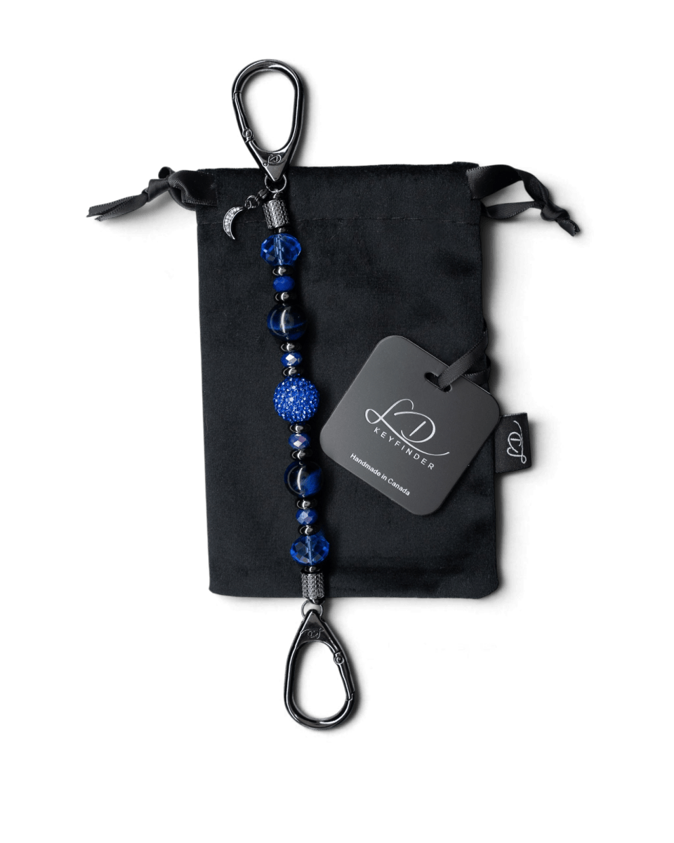 LD Keyfinder Midnight Sapphire beaded keychain with blue tiger eye, sapphire crystals, and a moon charm on velvet bag