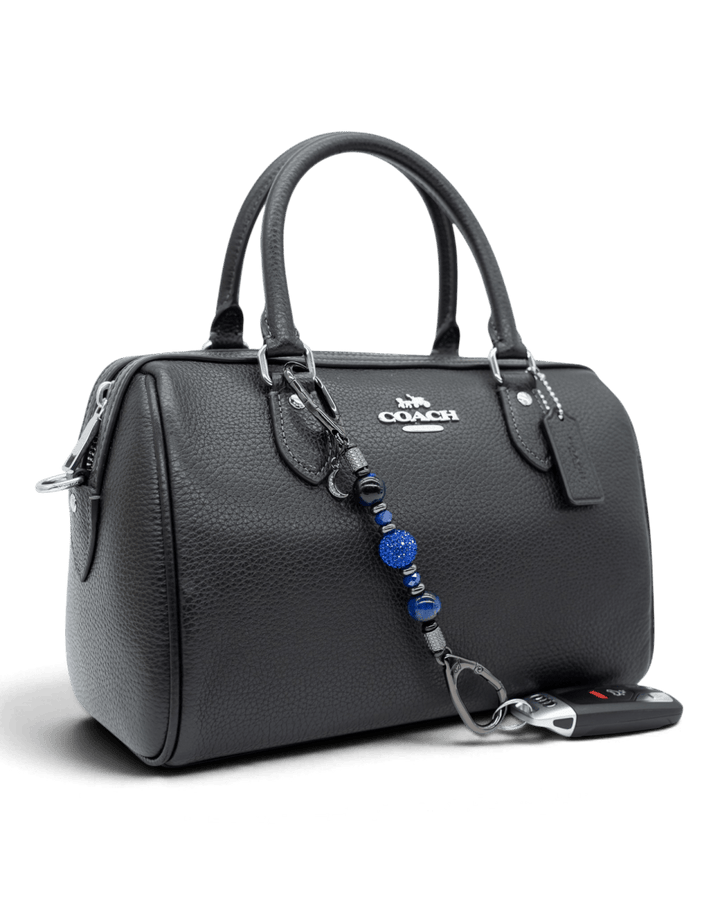 LD Keyfinder Midnight Sapphire Mini beaded keychain with blue tiger eye and sapphire crystals attached to a black bag