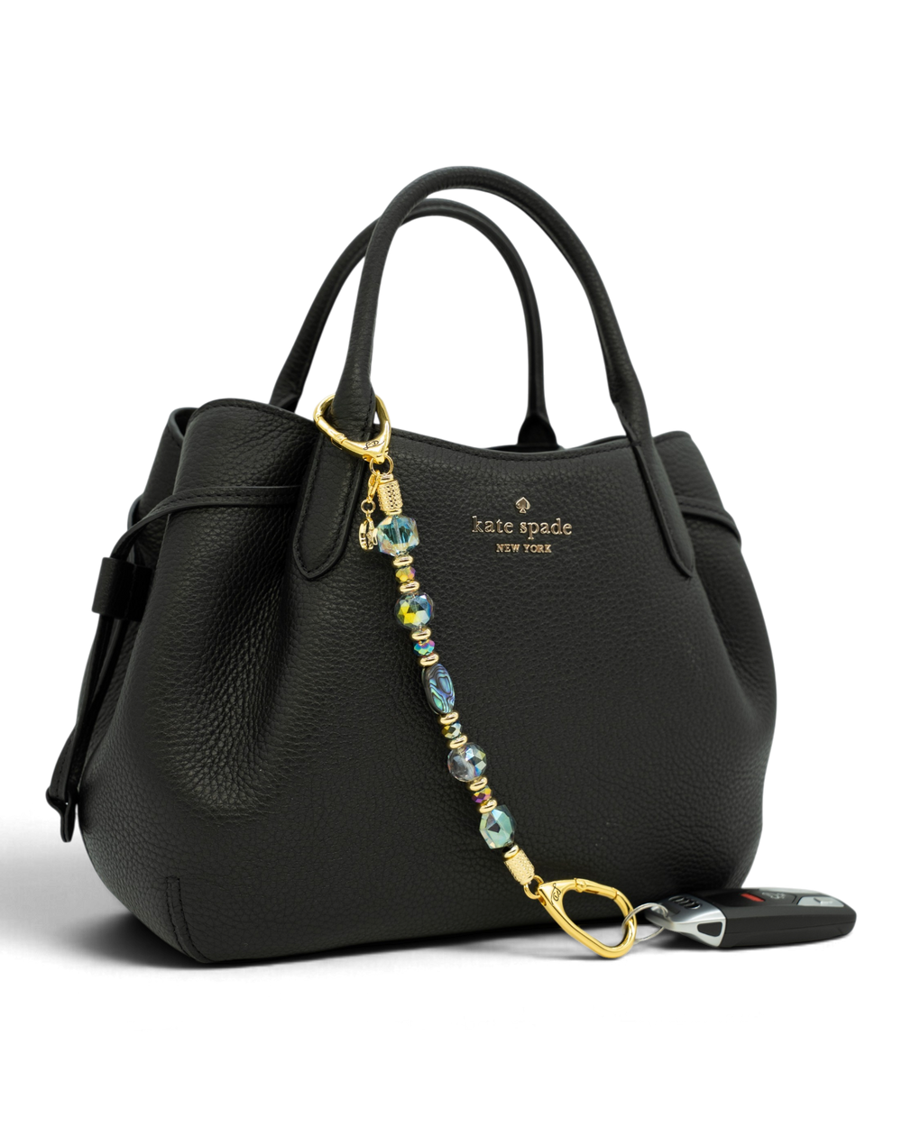 LD Keyfinder Northern Lights beaded keychain with abalone shell and rainbow crystal beads on a black leather handbag