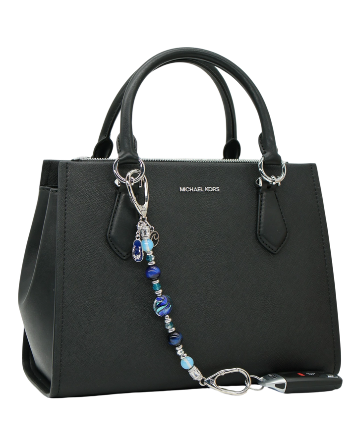 LD Keyfinder Ocean Mosaic beaded accessory with artisan glass, tiger eye, and charms attached to a black handbag