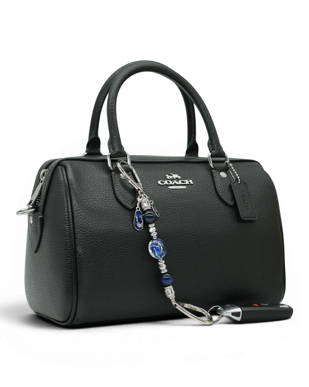 LD Keyfinder Ocean Mosaic Petite attached to a black leather handbag, featuring blue artisan glass and tiger eye beads.