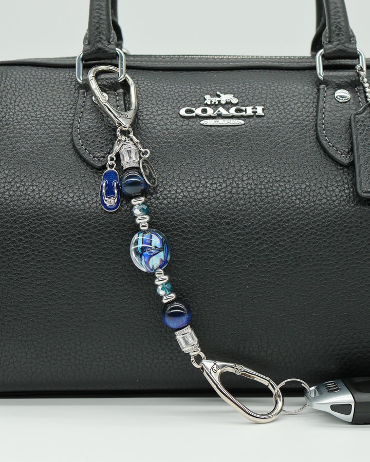 LD Keyfinder Ocean Mosaic Petite featuring artisan blue glass, tiger eye beads, and ocean charms on a black handbag