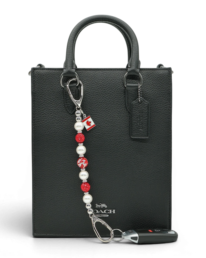 LD Keyfinder Oh Canada Shimmer keychain with red crystal, pearl, and Canada flag charm on black bag.