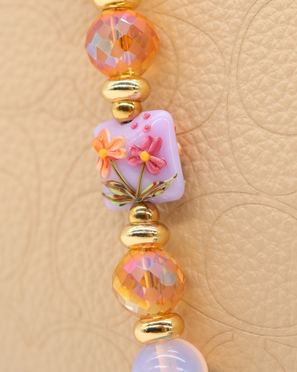 LD Keyfinder Petite Opalite Bloom bracelet with pink opalite, orange glass, and floral lampwork beads, gold accents, and hummingbird charm.