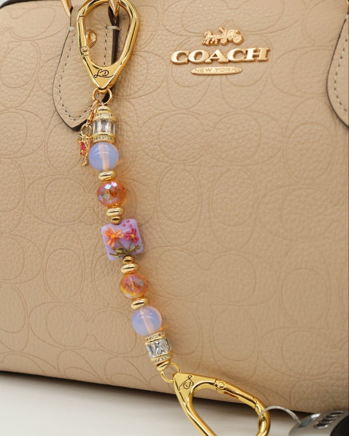 LD Keyfinder Petite Opalite Bloom keychain with pink opalite, burnt orange glass beads, and a ruby glass hummingbird charm.