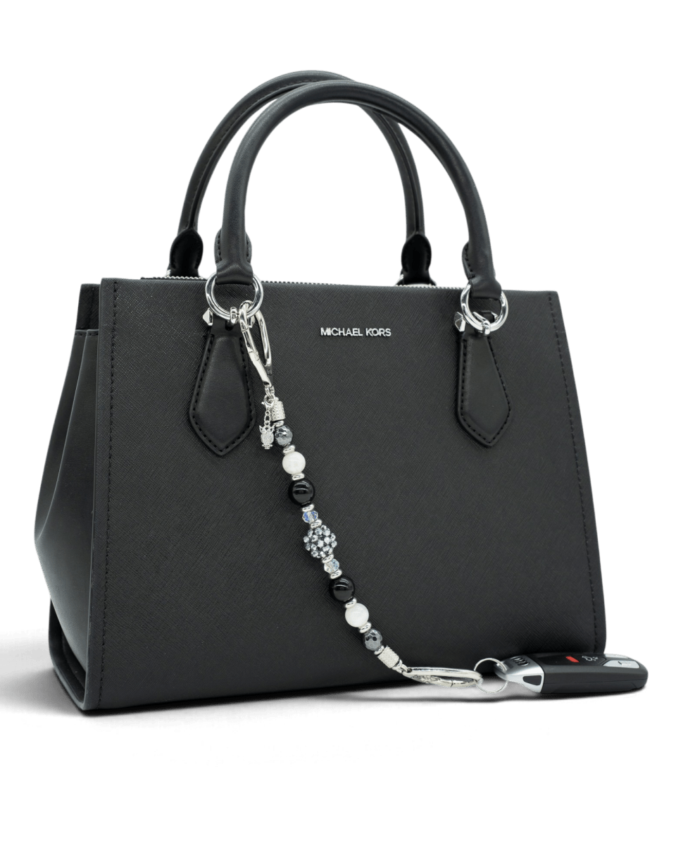 LD Keyfinder Owl That Glitters beaded accessory with obsidian, moonstone, and a sparkling owl charm on a black handbag