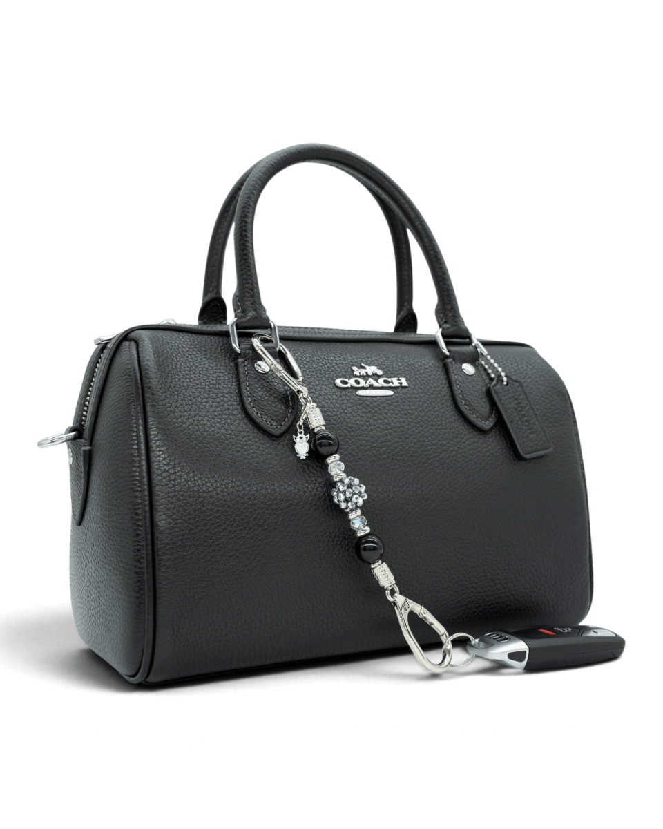 LD Keyfinder Owl That Glitters Mini beaded keychain with black obsidian and crystal charms attached to a black handbag.