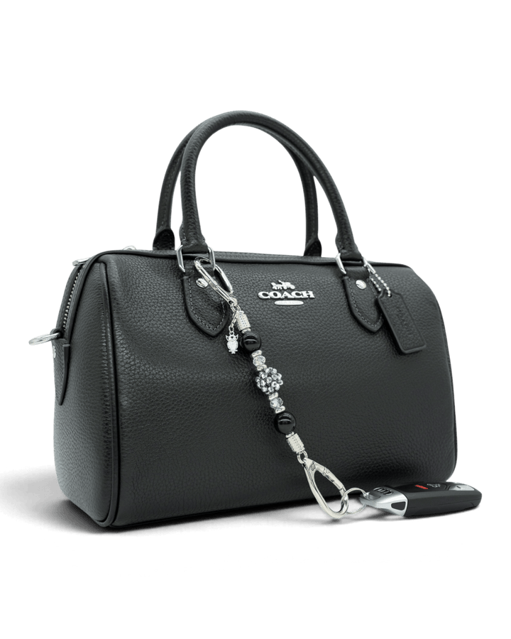 LD Keyfinder Owl That Glitters Mini beaded keychain with black obsidian and crystal charms attached to a black handbag.
