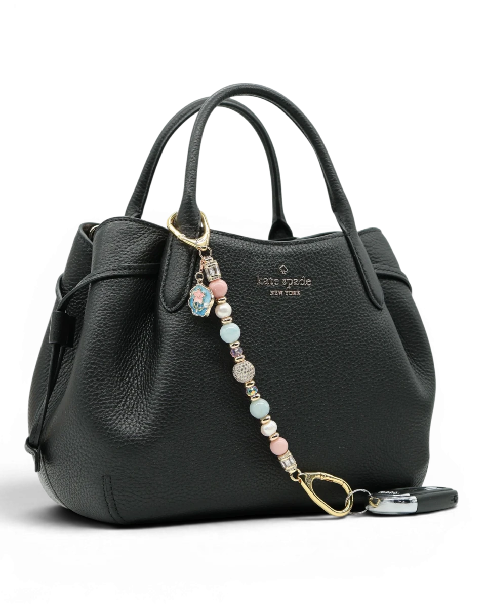 LD Keyfinder Pastel Garden charm with pink opal, pearls, aquamarine, and gold-plated beads on a black handbag.