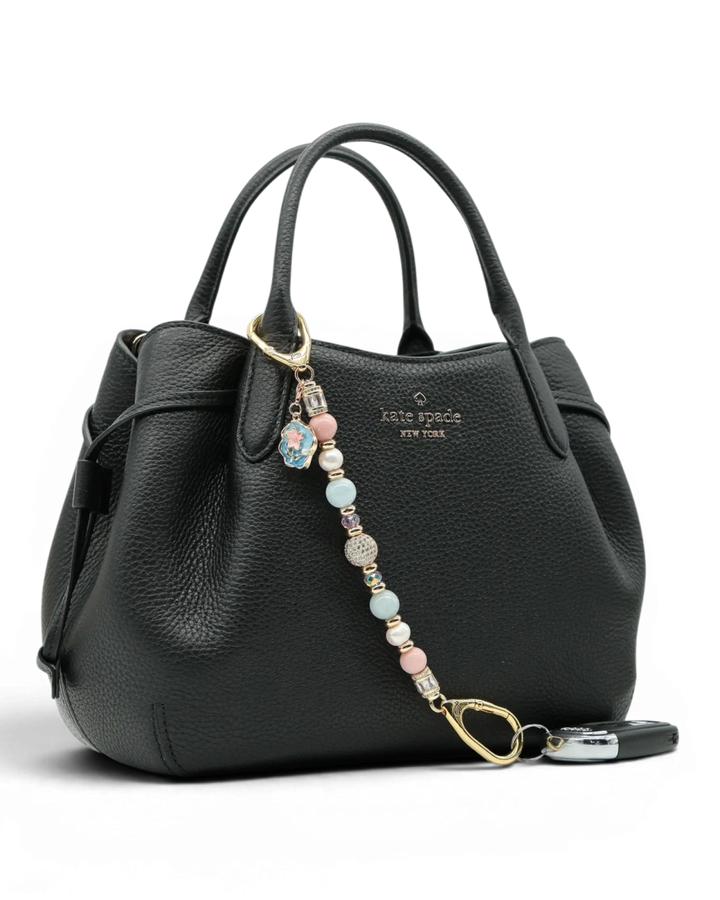 LD Keyfinder Pastel Garden charm with pink opal, pearls, aquamarine, and gold-plated beads on a black handbag.