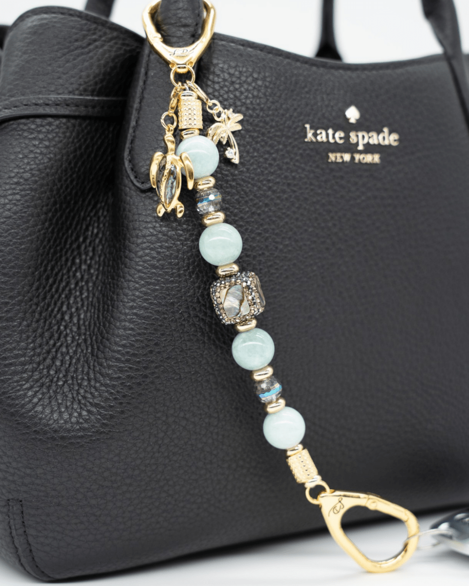LD Keyfinder Paua Paradise beaded keychain with aqua jade, paua shell, turtle and palm tree charms on a black bag.