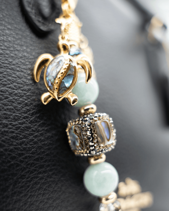 LD Keyfinder Paua Paradise Mini featuring aqua Malaysian jade, paua shell, and gold-plated turtle charm on black leather