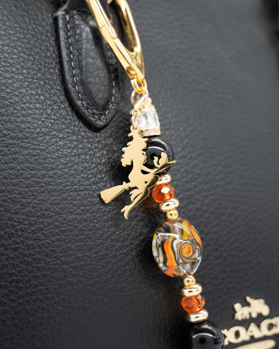 LD Keyfinder Petite Bewitched Halloween charm with black obsidian, orange glass beads, and a gold witch on a broom.