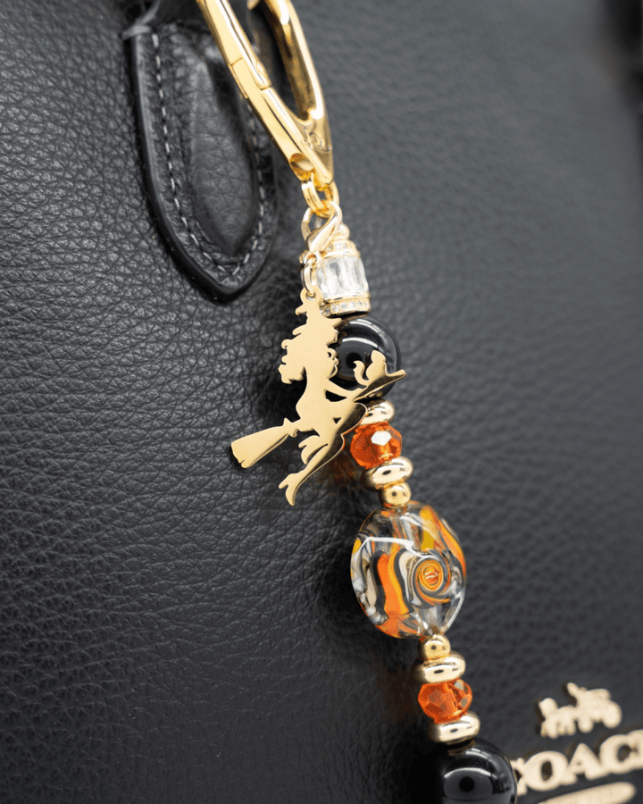 LD Keyfinder Petite Bewitched Halloween charm with black obsidian, orange glass beads, and a gold witch on a broom.