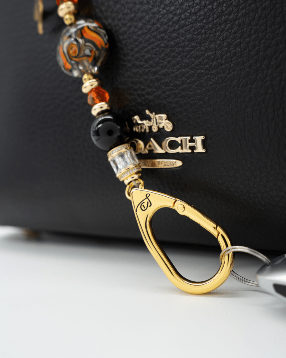 LD Keyfinder Petite Bewitched Halloween accessory with black obsidian, orange glass beads, and gold witch charm.